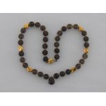 An 18 carat yellow gold and smokey quartz necklace, composed of circular facetted beads,