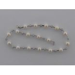 An 18 carat white gold, diamond and cultured pearl necklace,