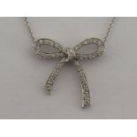 A platinum and diamond bow pendant, set overall with small brilliants, 2.