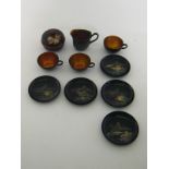 A Japanese lacquer part tea set, comprising three cups, five plates and a jug,