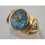 A 14 carat yellow gold and blue topaz dress ring, the central oval cut stone 10.