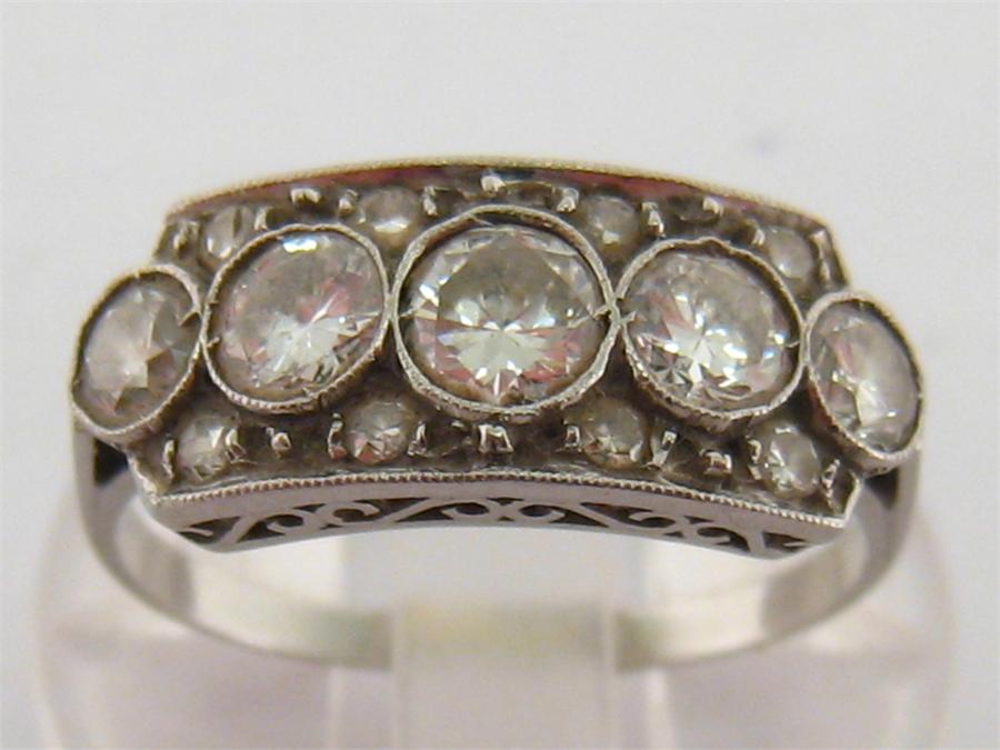 An Art Deco platinum and five stone diamond ring, the five graduated brilliants totalling approx.