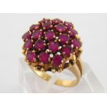 A 14 carat gold and ruby cluster ring, the cluster composed of 19 uniform round cuts each 3mm