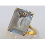 An 18 carat gold and blue topaz dress ring, the rectangular step cut stone 15.6 x 11.7mm, the