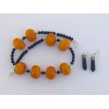 An amber and lapis bead necklace, the eight uniform butterscotch egg-yolk amber beads 24mm diameter,