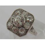 An Art Deco diamond and platinum plaque ring, the central old cut approx. 0.8 carat, above a