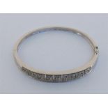 A 9 carat white gold and diamond bangle, the central open work panel of Greek key design pave set