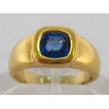 An 18 carat gold and sapphire ring, the cushion cut stone approx. 0.88 carat, rub over set, the