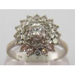 An 18 carat white gold and diamond cluster ring, the central brilliant 0.38 carat in a two tiered