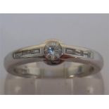 An 18 carat white gold and diamond ring, the central rub over set brilliant approx 0.25 carats, to