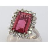 An 18 carat white gold, pink tourmaline and diamond dress ring, the central rectangular cut stone 12