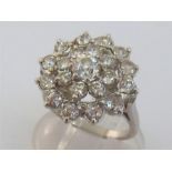 A diamond cluster ring, the large three tiered cluster of old brilliants centring on a large stone