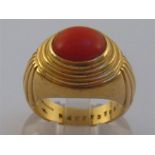 An 18 carat gold and coral ring, the rub over set domed red coral 9.4 x 7.6mm, the shank signed ‘