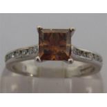 A cinnamon diamond ring, the claw set princess cut stone approx. 1.24 carat, to tension set