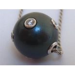 A South Sea black pearl and diamond pendant, the pearl 14.1mm, set overall with five collet set