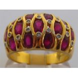 A ruby and diamond dress ring, the wide bombe bezel set with three rows of uniform oval cut rubies