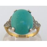 An Art Deco turquoise and diamond ring, the domed oval turquoise 15.6 x 11.1mm, to eight-cut set
