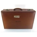 An Army and Navy Stores vintage leather suitcase with leather strip reinforced seams and cotton