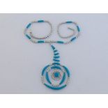 A diamond and blue stone necklace, the circular pendant and chain composed of alternate groups of