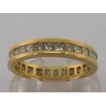 An 18 carat gold and diamond eternity ring, composed of a single line of calibre cut stones, the