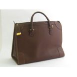 Gucci. A tan leather handbag with locking full length zip, drop handles, fabric lined, internal