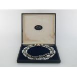 A three strand cultured pearl necklace, composed of three length strands of alternated black and