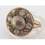 A black saltwater pearl and diamond ring, the central button pearl 7.1-7.4mm, in a surround of