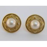 A pair of French cultured pearl and diamond ear clips, the boss design with central bouton pearl