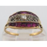 A ruby and diamond ring, composed of a graduated row of rose cut diamonds between two rows of