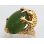 A nephrite ring, the large oval cabochon stone 18.8 x 13mm, in a yellow metal mount modelled as a