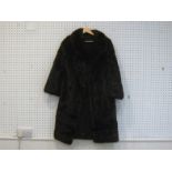 A three-quarter length brown mink coat, approx. size 12, with patterned brown silk lining, and inner