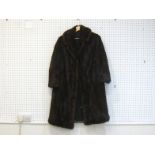 A medium sized three-quarter length brown mink fur coat, with brown patterned lining, with hook