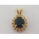 A sapphire and diamond cluster pendant, the central oval cut sapphire 8.9 x 7mm, in a surround of