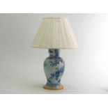 A large blue and white Chinese baluster shaped porcelain table lamp with figures at a table on