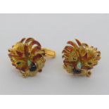 A pair of yellow metal (tests 18 carat gold) and enamel cufflinks, modelled as stylised lion’s