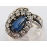 A sapphire and diamond ring, the off set pear cut sapphire approx. 1.06 carat, in a coiled