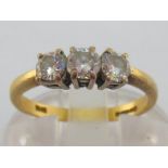 An 18 carat gold and three stone diamond ring, the the three slightly graduated brilliants totalling
