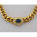 A sapphire and diamond necklet, the central cluster composed of an 8.2mm oval cabochon sapphire in a