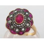 A synthetic ruby and diamond plaque ring, the cluster centring on an oval cut 5.5 x 4mm ruby, in a