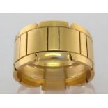 An 18 carat gold ring, the broad band with notched borders, signed to inner shank 'Cartier CM5204/