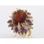 A garnet, opal, amethyst and diamond cluster dress ring, the central mixed cut oval garnet 14.9 x