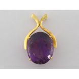 An amethyst pendant, the large oval stone 24mm long, in a yellow metal wishbone mount, stamped