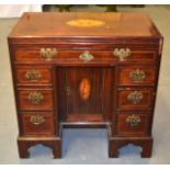 A SMALL EDWARDIAN KNEEHOLE WRITING DESK with inset shell top, over one long and six short drawers.