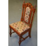 AN EARLY 20TH CENTURY SINGLE GOTHIC STYLE DINING CHAIR with elaborate upholstery.