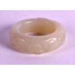 A SMALL CHINESE CARVED WHITE JADE ARCHERS RING 20th Century. 1.25ins diameter.