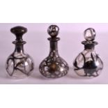 A SET OF THREE ART NOUVEAU SILVER OVERLAID SCENT BOTTLES. (3)