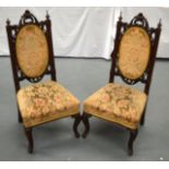 A PAIR OF 19TH CENTURY WALNUT SINGLE CHAIRS with scrolling back supports and floral upholstery.