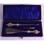 A CASED VICTORIAN STYLE SILVER HANDLED BUTTON HOOK together with a shoe horn & smaller hook.