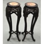 A PAIR OF 19TH CENTURY CHINESE CARVED HARDWOOD STANDS with marble tops and slender legs. 3Ft 1ins