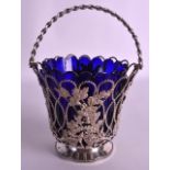 AN EDWARDIAN SILVER BASKET decorated all over with acanthus and foliage, with blue glass liner.